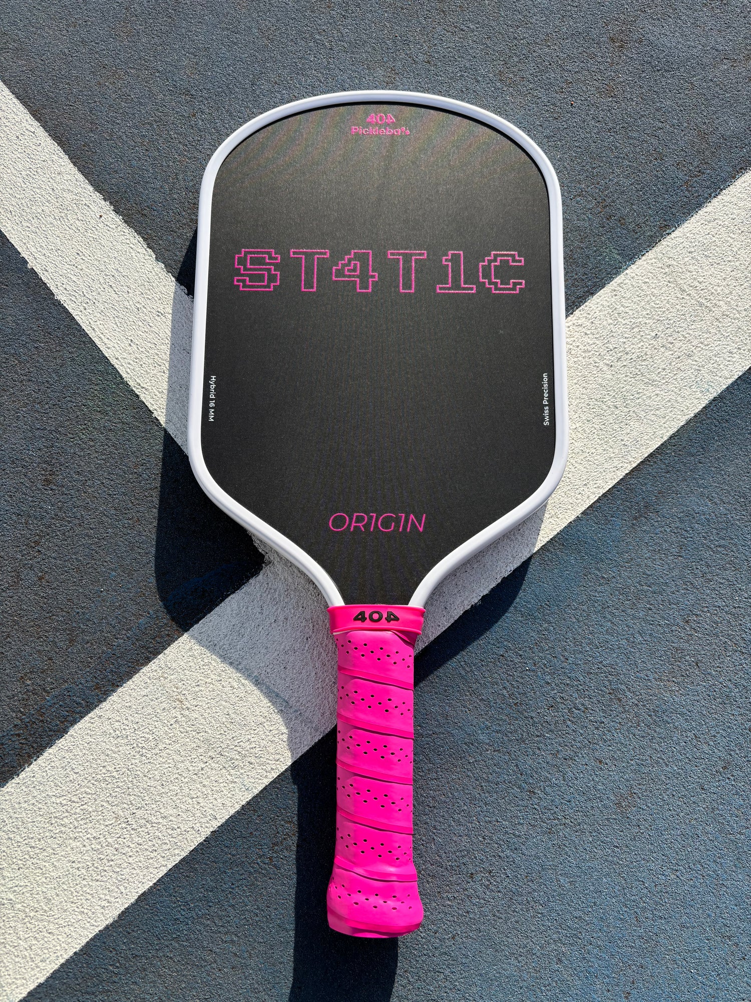 Pickleball paddle with pink handle on a court surface